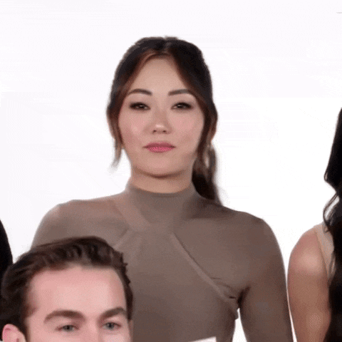 a group of people are standing next to each other and one of them is looking at the camera .