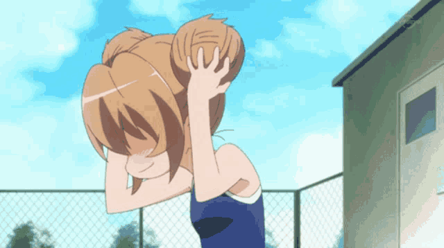 a girl in a swimsuit is covering her face with her hands
