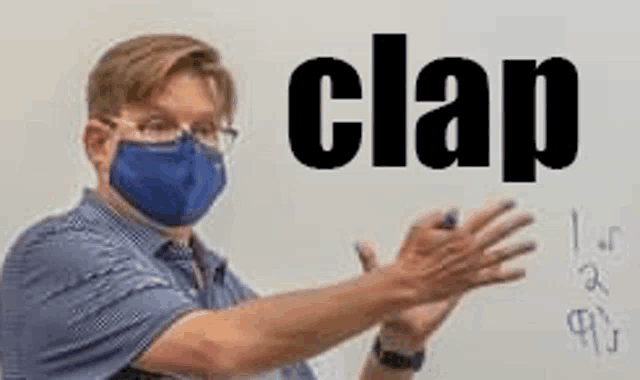 a man wearing a mask is clapping his hands in front of a whiteboard with the word clap written on it .