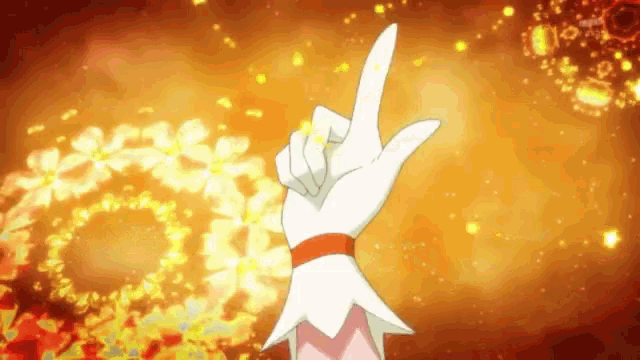 a person 's hand is pointing up in front of a fire ring .