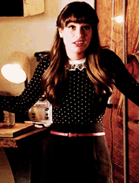 a woman wearing a black polka dot sweater and black pants