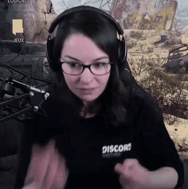 a woman wearing headphones and glasses is sitting in front of a microphone in a video game .