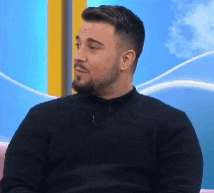 a man with a beard and mustache is wearing a black sweater