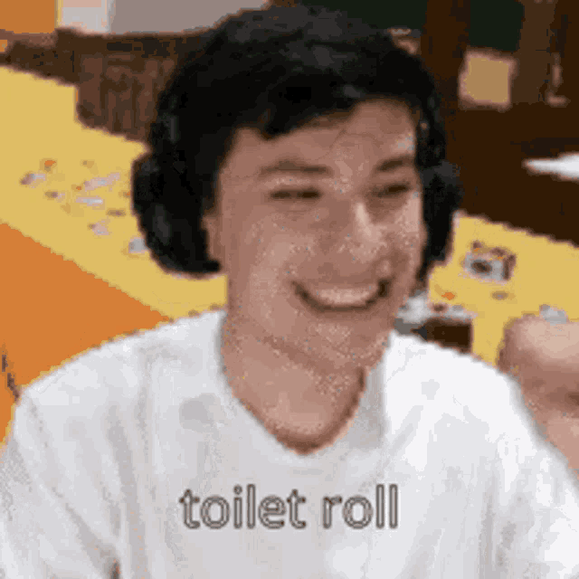 a man wearing headphones and a white shirt is smiling and says `` toilet roll '' .
