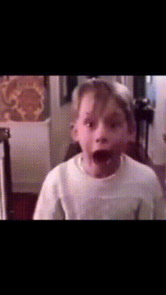 a young boy making a funny face while wearing a white shirt