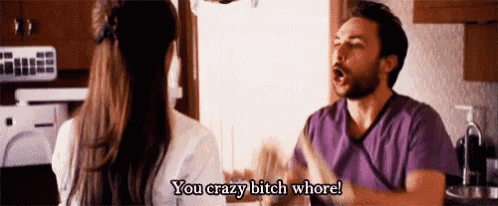 a man and a woman are having a fight in a kitchen and the man is yelling at the woman .