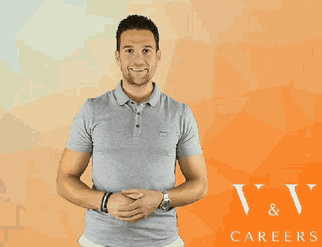 a man in a grey polo shirt stands in front of a v & v careers logo