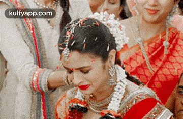 a bride is crying while surrounded by her family at a wedding
