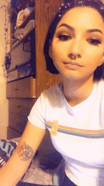a woman with a tattoo on her arm is wearing a white shirt