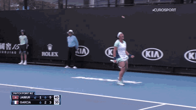 a woman on a tennis court with rolex and kia advertisements
