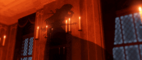a dark room with candles and a shadow of a man