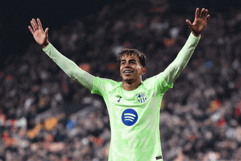a soccer player wearing a green jersey with a spotify logo