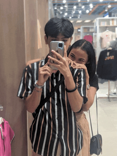 a man and a woman are taking a picture of themselves in the mirror