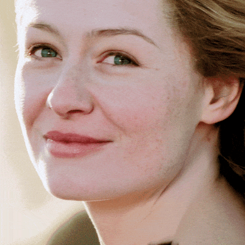 a close up of a woman 's face with a smile