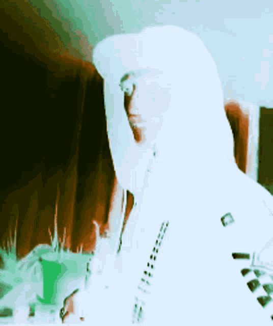 a man wearing a white hat and a white hoodie with a checkered pattern on the sleeves