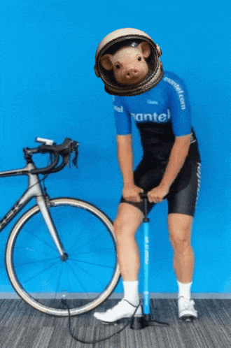 a man wearing a blue shirt that says mantel pumps his bicycle tire