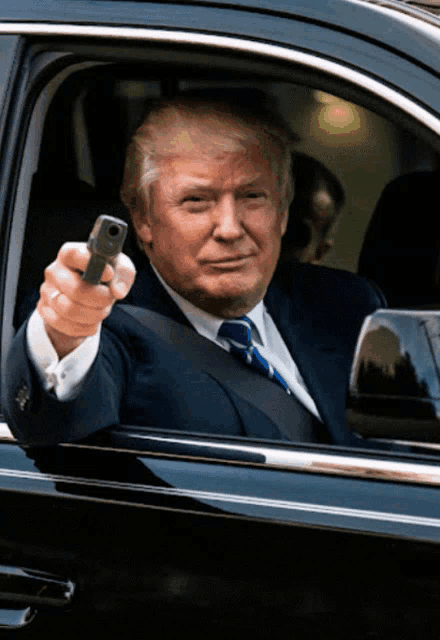 a man in a suit and tie is holding a gun