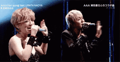 a woman singing into a microphone next to a man singing