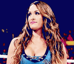 a pixelated image of a woman in a wrestling ring wearing a blue top that says ' tna ' on it