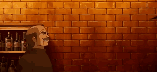 a man with a mustache stands in front of a brick wall behind a shelf with bottles of alcohol on it