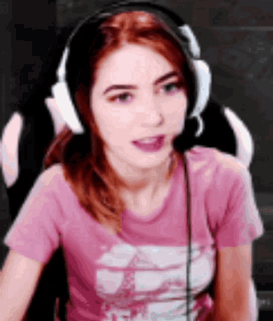 a woman is wearing headphones and a pink shirt