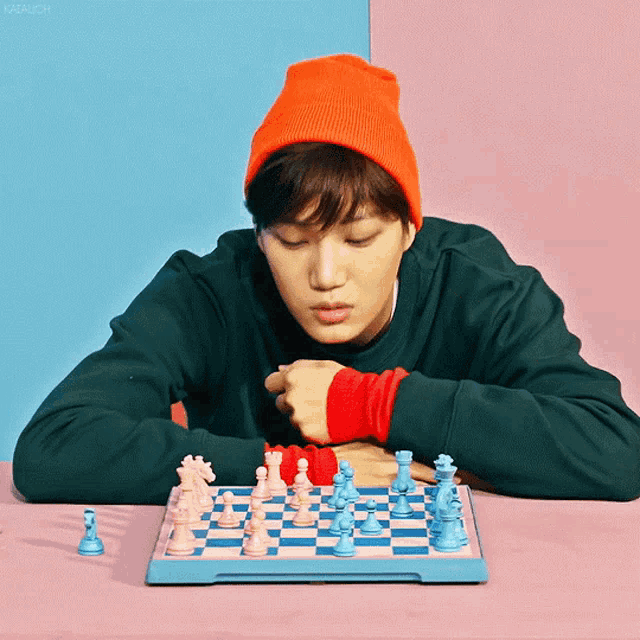 a man in an orange hat is playing chess