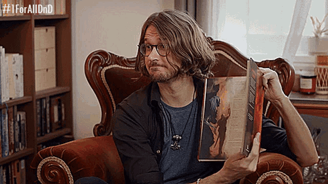 a man sitting in a chair reading a book with the hashtag #iforalldnd on the bottom right