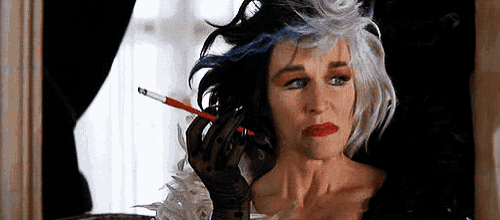 a woman is holding a cigarette in her hand and wearing a black glove .