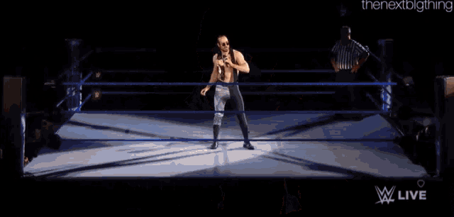 a wrestler named aiden english is holding a microphone in his hand .