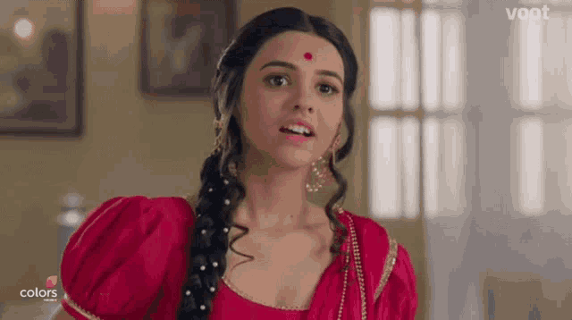 a woman in a red dress with a red dot on her forehead is on colors