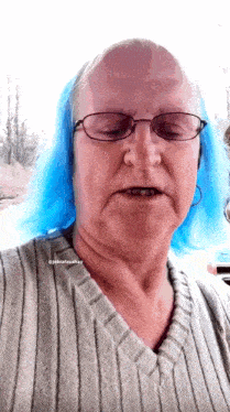 a woman with blue hair wearing glasses and a striped sweater