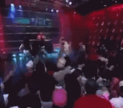 a blurred image of a crowd of people dancing in a club