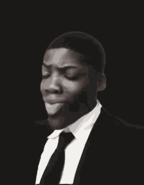 a man in a suit and tie is making a face