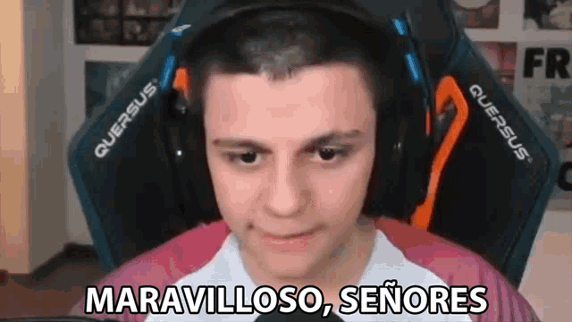 a man wearing headphones is sitting in a gaming chair and making a face .