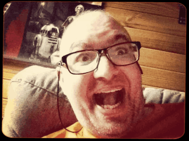 a man wearing glasses is making a funny face with his mouth open