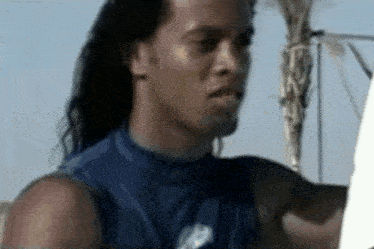a man with long hair is holding a surfboard in front of a palm tree ..