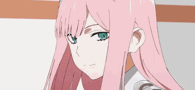a girl with pink hair and green eyes is looking at the camera