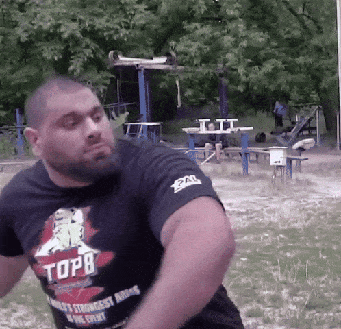 a man wearing a black top8 shirt is throwing a ball