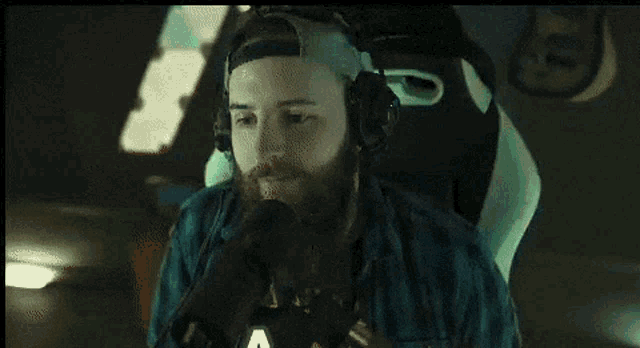 a man with a beard wearing headphones and a hat