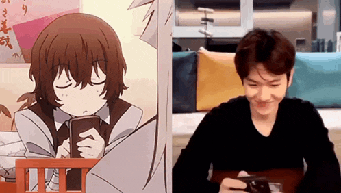 a man is sitting at a table looking at his phone next to a drawing of a girl holding a book .
