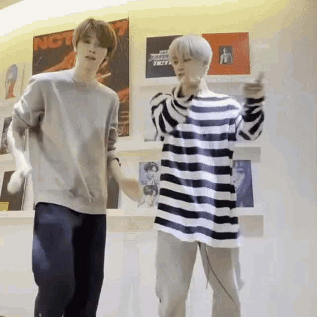 two young men are dancing together in a room .