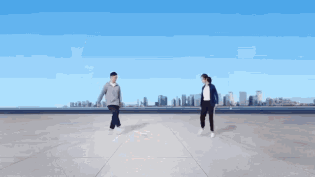 a man and a woman are standing next to each other on a concrete surface