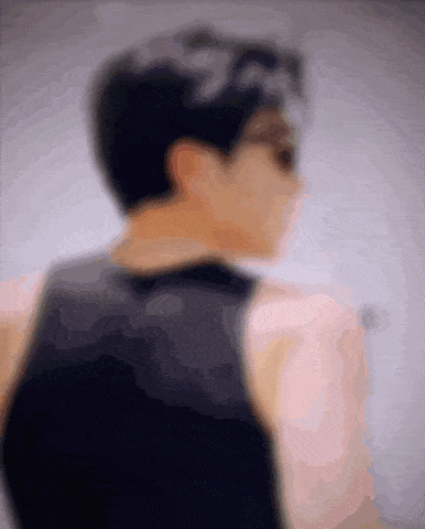 a blurry picture of a man wearing a black tank top and sunglasses