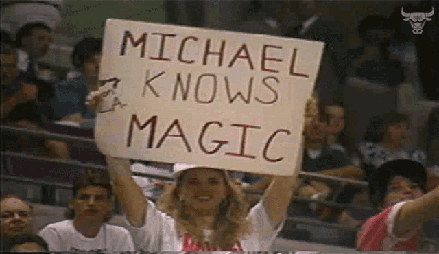 a woman holds a sign that says michael knows magic