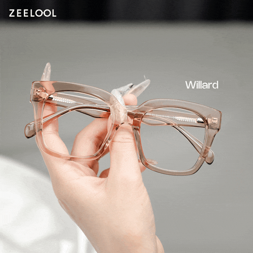 a person is holding a pair of glasses with the name willard on the bottom right