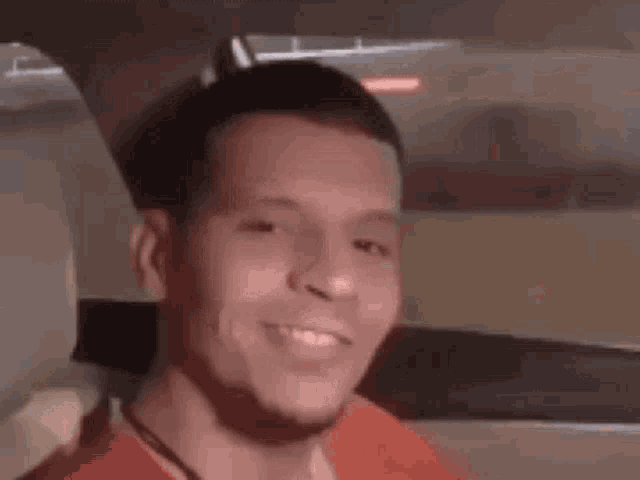 a man is sitting in the back seat of a car smiling .
