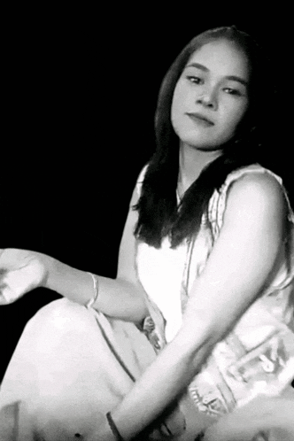 a black and white photo of a woman wearing a white shirt that says ' supreme ' on it