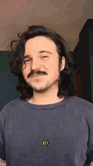 a man with long hair and a mustache is wearing a shirt that says ei