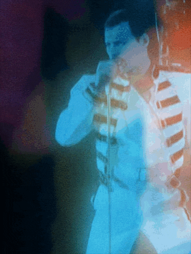 a blurry picture of a man singing into a microphone with a blue background