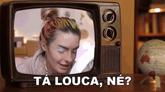 a woman is sitting in front of an old fashioned television with the words ta louca ne written on it